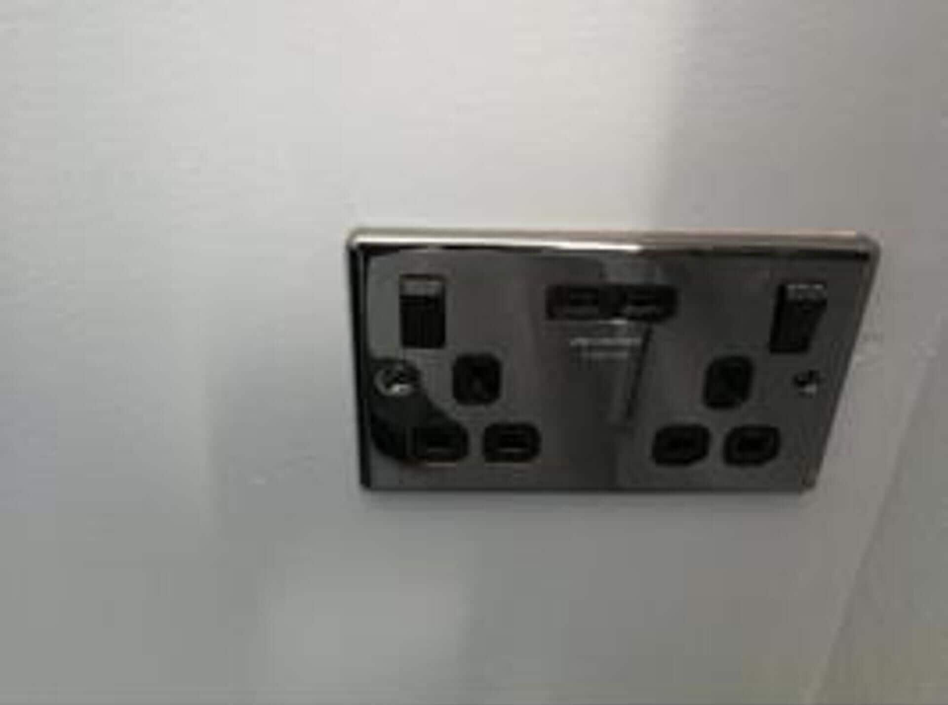 A wall-mounted electrical outlet with multiple sockets and switches.