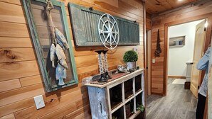 A wooden interior with a rustic decor, including a wall-mounted shelf with decorative items and a small potted plant. - New Spacious Northwoods Lakefront Getaway (Phelps)