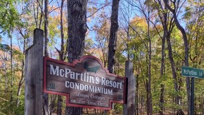 A sign for McPartlin's Resort Condominium in a wooded area. - New Spacious Northwoods Lakefront Getaway (Phelps)
