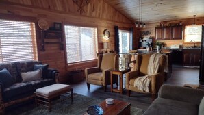 A cozy cabin interior with a living room, dining area, and kitchen. - New Spacious Northwoods Lakefront Getaway (Phelps)