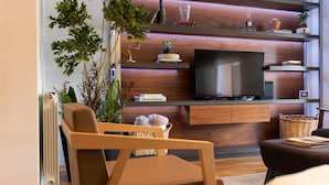 Un salon moderne avec un meuble TV en bois, un canapé confortable et une grande fenêtre.