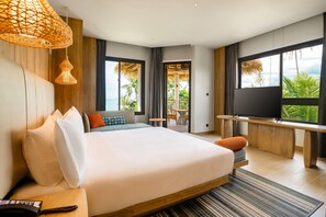 Quarto de hotel moderno com uma cama grande, televisão e vista para o exterior.