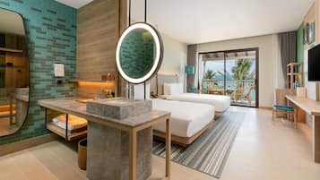 Habitación de hotel con una cama grande, una zona de estar con una mesa y sillas, un baño con tocador y un balcón con vistas.