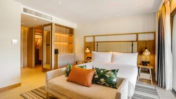 Una habitación de hotel con cama, sofá, mesita de noche y vestidor.