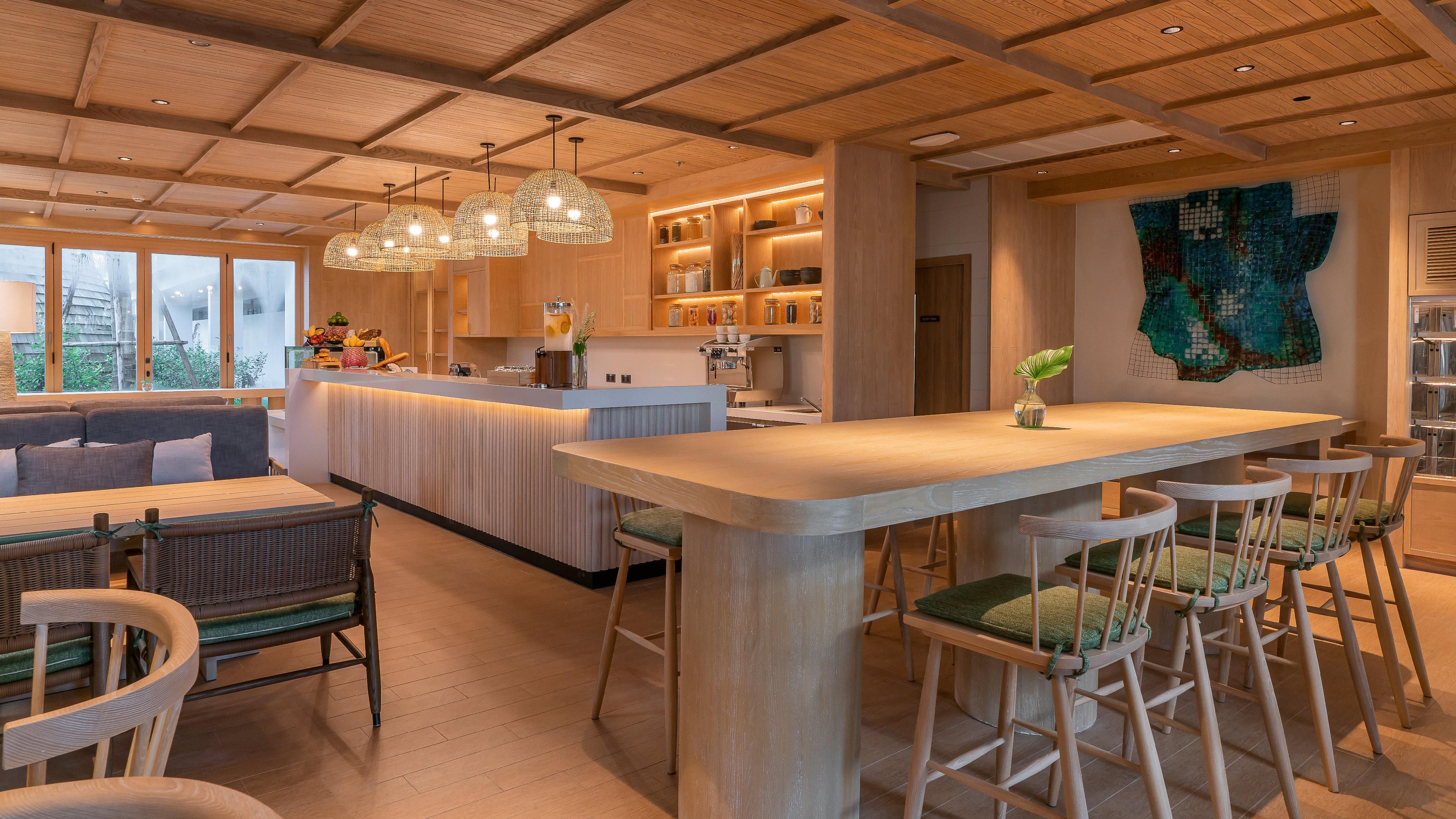 A modern kitchen with wooden cabinetry, a central island, and bar stools.