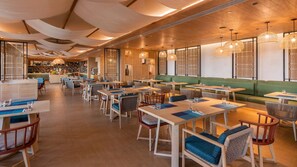 A modern restaurant with wooden floors, green seating, and woven light fixtures. - Holiday Inn Resort Samui Bophut Beach (Koh Samui)