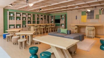Un interior moderno con muebles de madera, una zona de bar y paredes verdes.