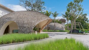 A modern building with a unique spherical design, surrounded by lush greenery and palm trees. - Holiday Inn Resort Samui Bophut Beach (Koh Samui)