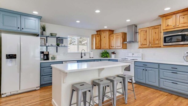 A modern kitchen with a central island, wooden cabinets, and a stainless steel microwave. - Stay & Gather in Luxury! So close to Everything! (Orem)