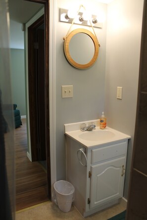 Bathroom features a vanity, mirror, and bathtub.