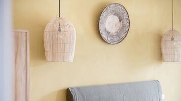 Un dormitorio con una cama, una lámpara de pared y un plato decorativo.