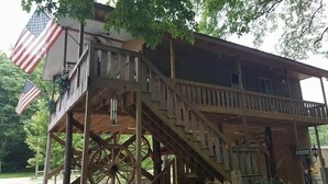 Een houten constructie met een balkon, een Amerikaanse vlag en een groot houten rad.