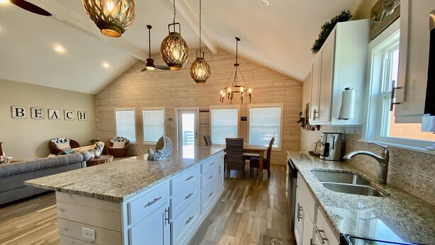 A spacious kitchen with a large island, wooden ceiling, and a view of the beach. - New Listing in Paradise Point Community (Port Aransas)