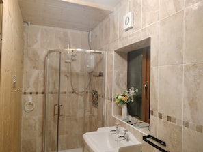 A bathroom with a glass-enclosed shower, a white sink, and a mirror above it. - One Bedroom Apartment Achill Island Pets Allowed (Achill Island)