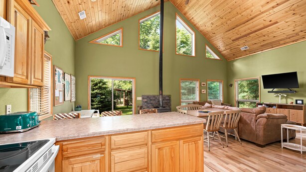 A spacious kitchen with wooden cabinets, a central island, and a large window.