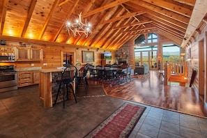 Cozy cabin with a large open dining area, fireplace, and kitchen with modern appliances.