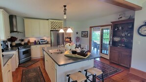 Una cocina con una isla central, electrodomésticos de acero inoxidable y armarios de madera.