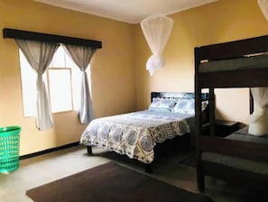 Cozy retreat with a single bed, wooden bunk bed, and a window with curtains.