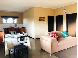 Cozy living space with a kitchenette and seating area, featuring a sofa and small rug.