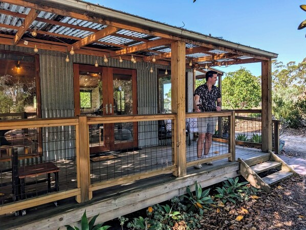A wooden covered porch with a railing, a wooden deck, and a view of the surrounding landscape. - Accessible & Inclusive studio Barossa Valley SA: It's Bonza! Mill About Vineyard (Williamstown)