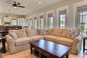 Relax in this stylish living room with a large sofa, coffee table, and kitchen area.
