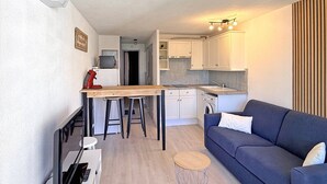 A compact living space with a kitchenette, a dining area, and a seating area.