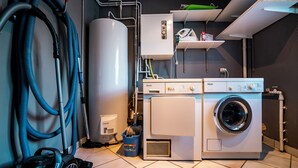A laundry room with a washing machine, a dryer, a water heater, and a vacuum cleaner. - 14 person chalet, 100m from the Super-Chatel gondola - Chatel Reservation (Châtel)
