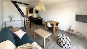 Eine moderne Wohnung mit Wohnzimmer, Essbereich, Küche und einer Treppe.