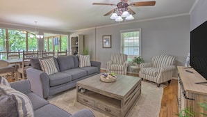 A spacious living room with a gray sofa, striped armchairs, a wooden coffee table, and a ceiling fan. - ‘The Lake Escape’: Boat Dock, Fire Pit, Kayak! (Vincent)