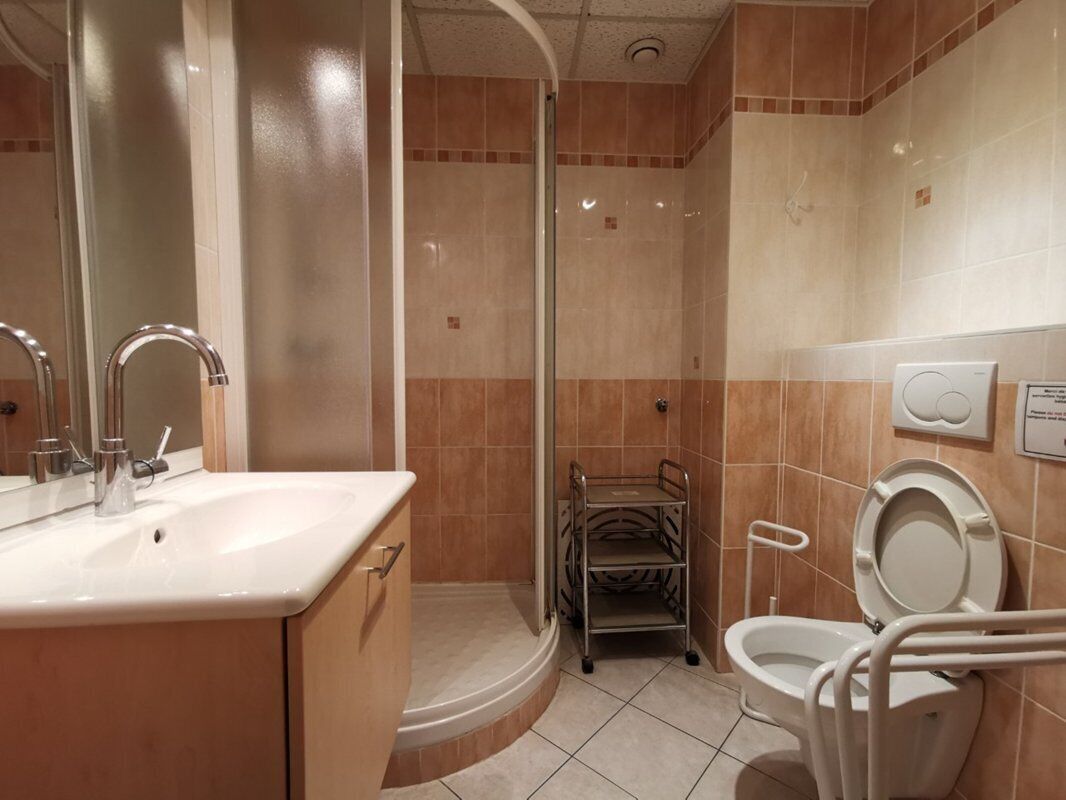 Ein Badezimmer mit Waschbecken, Spiegel, Toilette und Duschkabine.