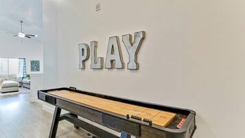Et billardbord med ordet 'PLAY' på væggen over.
