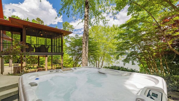 A hot tub with a control panel, surrounded by trees and a wooden deck. - Graceland (Clarksville)