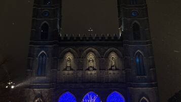 Església històrica amb dues torres geminades i un gran arbre il·luminat amb llums blaves al centre.