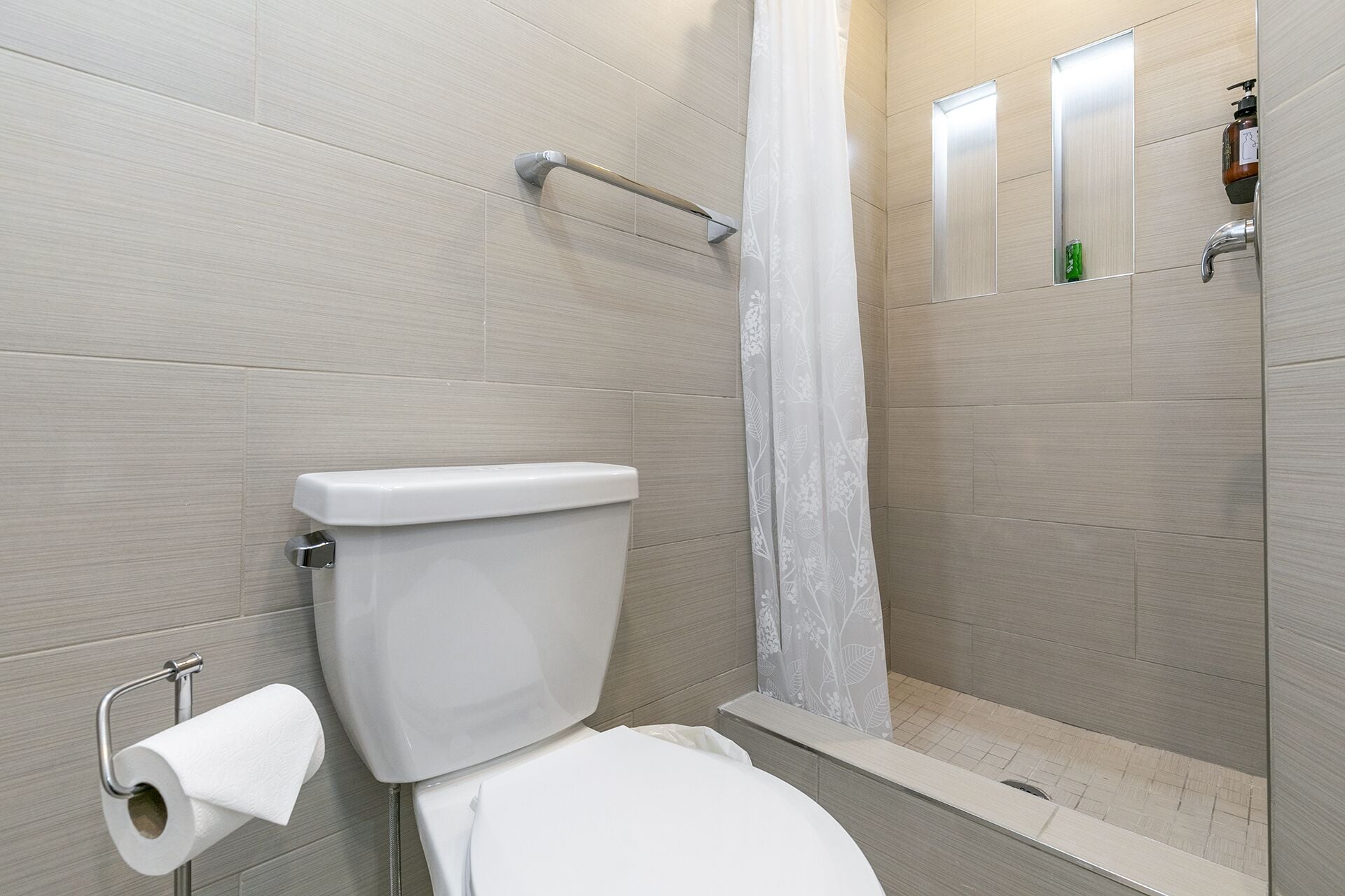 Ein Badezimmer mit Toilette, Duschvorhang und Spiegel.