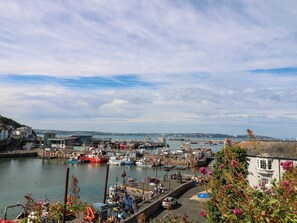 A harbor with boats, a dock, and a building with a sign. - Bay View (Brixham)