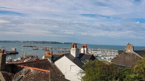 A coastal town with buildings, a marina, and boats. - Bay View (Brixham)