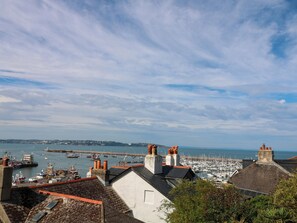 A coastal town with buildings, a marina, and boats. - Bay View (Brixham)