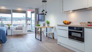 Eine moderne Wohnung mit Essbereich, Küchenzeile und einem Balkon mit Blick.