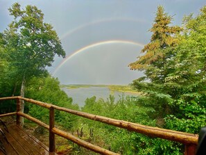 A wooden deck overlooking a lake with a rainbow. - Off Grid, Remote Alaskan Bristol Bay Fishing Lodge (Fly in ONLY!) (Iliamna)