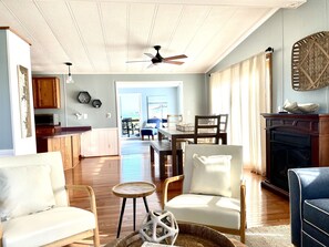 Amplia sala de estar con chimenea, comedor y cocina.