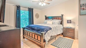 A bedroom with a bed, a nightstand, a ceiling fan, a window with curtains, and a view of the outdoors. - Mt Pleasant Retreat w/ Grill: 10 Mi to Beach (Mt Pleasant)