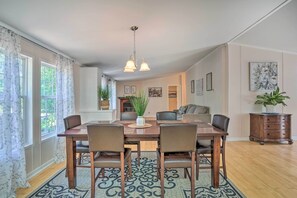 A dining area with a wooden table and chairs, a hanging light fixture, and a patterned rug. - Mt Pleasant Retreat w/ Grill: 10 Mi to Beach (Mt Pleasant)