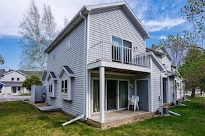 A two-story house with a balcony, a covered porch, and a garage. - Prime Fish Creek Location: Holiday by the Bay (Fish Creek)