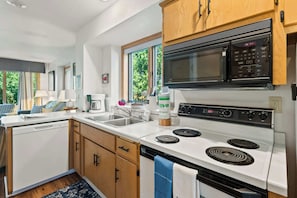 A modern kitchen with a microwave, stove, and sink.