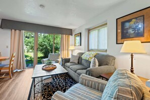 A living room with a sofa, armchairs, a coffee table, and a dining area with a table and chairs.