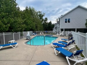 A rectangular pool with a surrounding deck, lounge chairs, and a white fence. - Prime Fish Creek Location: Holiday by the Bay (Fish Creek)