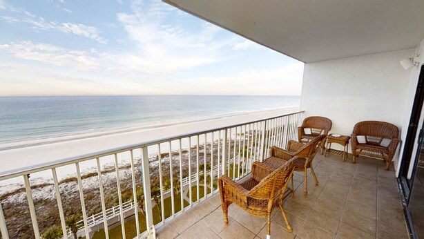 A balcony with wicker furniture overlooking a beach. - SUNRISE /SUNSET GULF VIEWS #932 - FREE BEACH CHAIRS!!!!! (Panama City)
