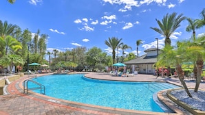 A swimming pool with a brick walkway, palm trees, and lounge chairs. - Vista Cay Resort Condo ~ 5 Mi to Universal! (Orlando)