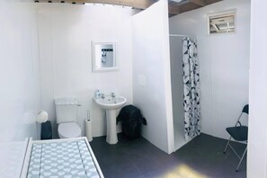 Un baño pequeño con inodoro, lavabo y ducha.