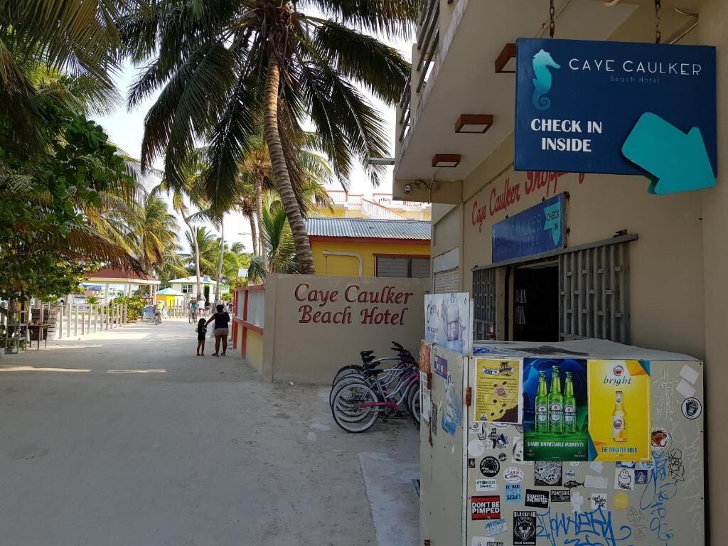 La façade de l’hôtel Caye Caulker Beach, avec une pancarte indiquant « Enregistrement à la réception ».